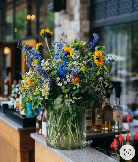 Sunflower Table Decoration, Yellow Blue Floral Arrangement, Sunflower With Blue Flowers, Blue Floral Table Arrangements, Wildflower Vase Arrangements, Blue And Yellow Flower Centerpieces, Sunflower And Wildflower Bouquet, Diy Wildflower Wedding Decor, Chamomile Centerpiece