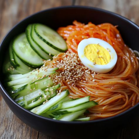 🌶️🍜 Cool off with the spicy kick of Bibim Naengmyeon—perfectly refreshing and packed with flavor! 😋 #BibimNaengmyeon #KoreanFood Bibim Naengmyeon (Spicy Cold Noodles) Ingredients: Naengmyeon noodles (200g) Cucumber (1, julienned) Carrot (1, julienned) Korean red pepper paste (Gochujang, 3 tbsp) Sesame oil (1 tbsp) Vinegar (2 tbsp) Sugar (1 tbsp) Soy sauce (1 tbsp) Garlic (2 cloves, minced) Boiled egg (1, sliced) Sesame seeds (1 tbsp) Green onion (1, chopped) Instructions: Cook naengmyeon ... Jjajangmyun Recipe, Bibim Naengmyeon, How To Make Jjajangmyeon Korean, Vegan Jjajangmyeon Recipe, Jajamyeong Noodles, Jajamyeon Noodles Korean, Cold Noodles Recipes, Korean Cold Noodles, Cozy Fall Recipes