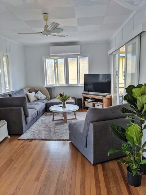 Grey Couch Living Room Dark Floors, Grey Couch Hardwood Floors, Brown Floors Grey Couch, Grey And Plants Living Room, Grey Couch With Wood Furniture, Light Gray Couch Living Room Tv Stand, White Wall Grey Couch, White Walls Dark Grey Couch, Gray Couch Wood Floors Living Room