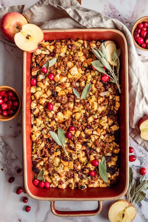 Say hello to the best Thanksgiving stuffing! This easy Sausage Apple Cranberry Stuffing is full of toasty sourdough bread, sausage crumbles, sweet apple, fresh herbs, and dried cranberries. This baked casserole is irresistible with golden toasted edges and a soft, moist center - talk about a perfect side dish! Stuffing With Sausage Apples And Cranberries, Sausage Cranberry Apple Stuffing, Sausage Apple Cranberry Stuffing Recipe, Sausage Apple Cranberry Sourdough Stuffing, Sage Sausage And Apple Stuffing, Rosemary Stuffing, Stuffing Ingredients, Sage Sausage, Sausage Casserole