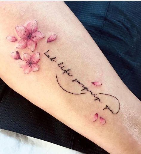 24 Fascinating Cherry Blossom Tattoo Designs For 2021 Cherry Blossom With Words Tattoo, Cherry Blossoms Tattoos For Women, Small Flowers Tattoo Design, Sakura Tattoo Design Cherry Blossoms, Cherry Blossom Infinity Tattoo, Cherry Blossom Tattoo With Names, Unique Cherry Blossom Tattoo, Cherry Blossom Name Tattoo, Cherry Blossom Tattoo On Back Spine