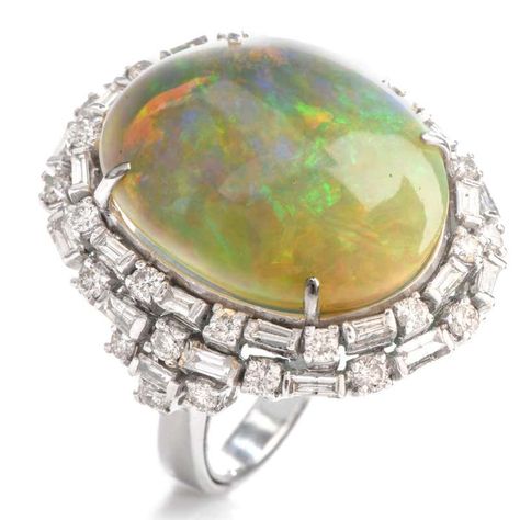 For Sale on 1stdibs - This eye catching cocktail ring boasts of color with a large oval shaped fiery Opal offering bursts of red, green and blue. With the Opal measuring appx. Luxury Cabochon Opal Ring For Engagement, Luxury Multi-stone Dome Ring For Engagement, Sapphire Cocktail Ring, Opal Band, Yellow Gold Wedding Band, Jewelry Appraisal, Diamond Cocktail Rings, Double Halo, Domed Ring