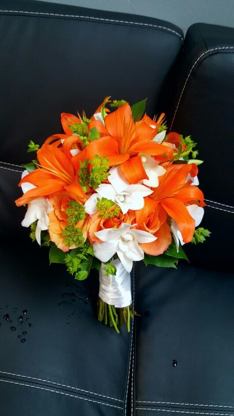 Orange Asiatic lilies and Roses accented with white dendrobium Orchids.  Designed by Ms Scarlett's Flowers Orange And White Bouquet Brides, Orange Prom Flowers Bouquets, Prom Bouquet Ideas Orange, Orange Lily Wedding Bouquet, Orange And White Flower Bouquet, Orange Tiger Lily Bouquet, Orange Bouquet Prom, Orange Prom Bouquet, Orange Prom Flowers