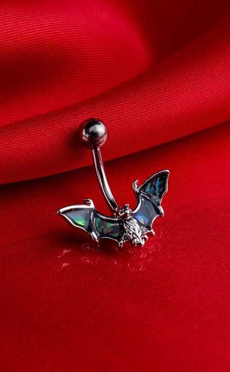 Created from 316L surgical steel, this beautiful piece has a bat with wings made from genuine abalone shell, and a curved barbell stud making it perfect for the navel. Material: Surgical Steel. Type: Belly Ring. Gauge: 14G. Length: 10mm. Colour: Silver & Abalone. Suitable Piercing: Upper Belly Button & Lower Belly Button. Frog Belly Button Ring, Punk Belly Button Piercing, Spider Belly Button Ring, Bat Belly Button Piercing, Dragonfly Belly Button Piercing, Belly Button Jewellery, Gothic Belly Button Piercing, Goth Belly Button Piercing, Top And Bottom Belly Piercing