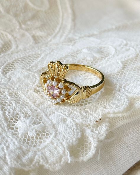 Fall head over heels for the Irish Promise Ring! This Claddagh design symbolizes love and is perfect for Irish lovers. Fit for a queen, with 18kt gold plating, pink cubic zirconia, and faux pearls. Stack it with other rings for an even more regal look! Pink Pearl Wedding Ring, Perfect Gifts For Girlfriend, Vintage Claddagh Ring, Claddagh Ring Meaning, Cute Promise Rings Girlfriends, Vintage Promise Rings, Irish Promise Rings, Claddagh Ring, Pink Heart Rings