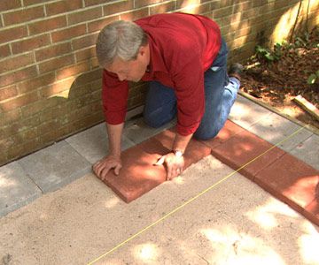 Begin laying the pavers against the house, making sure each one is even and the top surface is flush with the string. How To Lay Pavers, Pavers Diy, Diy Patio Pavers, Brick Laying, Paver Designs, Patio Pavers Design, Paver Walkway, String Crafts, Brick Pavers