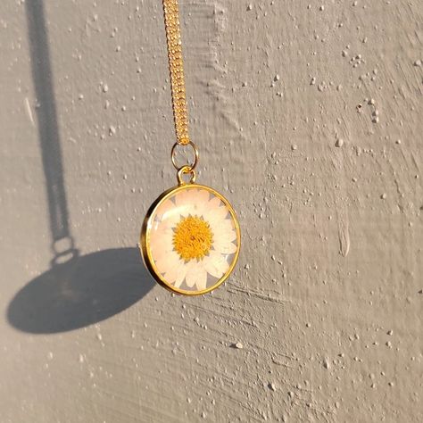 White Daisy Pendant with golden chain 🌸 Dm us to buy. Bezel : @resinsm_silicone_moulds White daisy. : @craft__supply #resinjewelry #resinartwork #resinearrings #jewellery #handmaderesinjewelry #smallbusiness #giftjewelry #preservationresin #dryflowerresinjewelry #resinhandmadejewellery #originalflowerjewellery #resininkjewellery #floralresinjewelry #resinearstuds#whitedaisyjewellery Flower Resin Jewelry, Daisy Pendant, Silicone Moulds, Instagram White, Golden Chain, Resin Artwork, White Daisy, April 16, Craft Supply