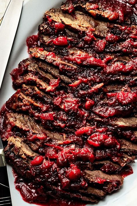 This nearly effortless brisket gets a festive garnet glaze from cranberries; their tart sweetness cuts through the super-savory onion soup mix and hearty brisket with ease. Double-roasting the brisket yields incredibly tender meat that soaks up the concentrated sauce.#bbq #barbecue #barbeque #bbqrecipes #brisket #brisketrecipes Cranberry Brisket Recipes Oven, Hanukkah Brisket, Christmas Brisket, Cranberry Dishes, Beach Foods, Jewish Brisket, Holiday Brisket, Hanukkah Recipes, Brisket Oven