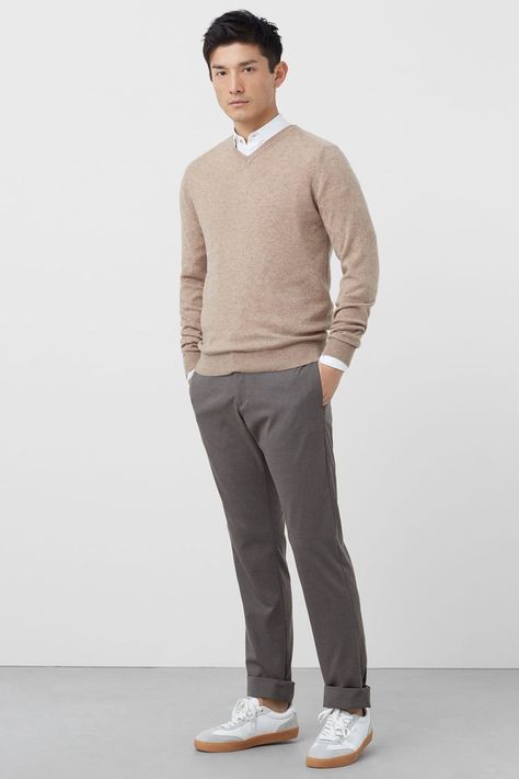 Men's grey chinos, white shirt, beige merino V-neck sweater and white gum sole sneakers outfit with no socks. This outfit was included in the article: Shirt Under A Sweater: 21 Ways To Wear This Classic Combination, on MensFlair.com Cream Mens Outfit, Sweater And Dress Shirt Men, Shirt Under Sweater Outfit Men, Grey Chinos Men Outfits Casual, Beige Chinos Men Outfits Casual, Gum Sole Sneakers Outfit, Beige Combination Outfit, Sweater Chino Outfit Men, Beige Sweater Outfit Men