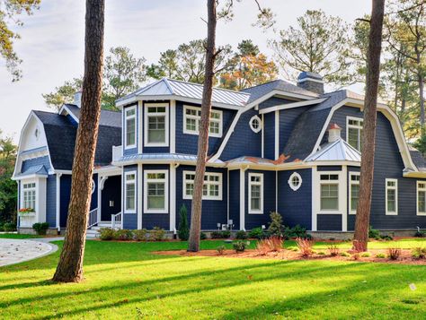 This gorgeous gambrel-style house is painted in Naval SW 6244, a deep blue that resonates against the white trim and surrounding landscape. Discover exterior paint colors that will make your home stand out. Wall Cladding Designs, Grey Exterior House Colors, Exterior House Siding, Cladding Design, Gambrel Roof, Pintura Exterior, Exterior Paint Color, Exterior Color Schemes, Exterior Paint Colors For House