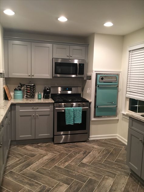 Gray cabinets, vintage wall oven, teal accents, herringbone tile flooring pattern Gray And Turquoise Kitchen, Gray And Aqua Kitchen, Teal Grey Kitchen, Teal Accents In Kitchen, Gray And Teal Kitchen Ideas, Teal And Gray Kitchen Decor Ideas, Grey And Aqua Kitchen, Turquoise And Grey Kitchen, Black Teal Kitchen