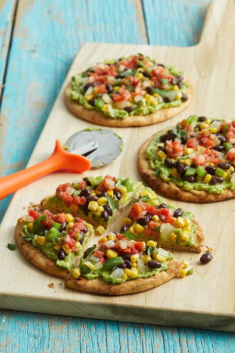 When you have fresh pita bread on hand—or any other flatbread, for that matter—homemade pizza is just minutes away. Topped with a tasty corn and black bean combo, these Tex-Mex pita pizzas are assembled after the pita crusts have been crisped in the oven so they won’t get soggy. We’ve kept the topping mild so it will appeal to adults and kids alike, but you can always adjust the heat level with the salsa you choose. Pita Pizza, Pan Pita, Pita Pizzas, Pain Pita, Forks Over Knives, Vegan Pizza, Pita Bread, Good Pizza, Meatless Meals