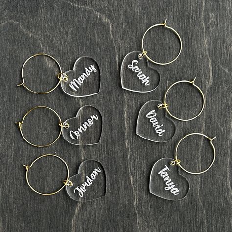 Get ready to add some pizzazz to your party with these amazing personalized clear wine charms! With six unique and custom-engraved charms, your guests are sure to have a blast identifying their glasses with ease. Not only do these charms add a touch of elegance to your guests' wine glasses, they also serve a practical purpose by ensuring that no one accidentally sips from someone else's glass. Made from high-quality clear acrylic and featuring gold and silver charm rings, these wine charms are d Bridesmaid Baskets, Bridal Shower Favours, Drink Charms, Ideas Bodas, 21st Bday Ideas, Custom Wine Glass, Bachelorette Decorations, Summer Tea, Glass Charms