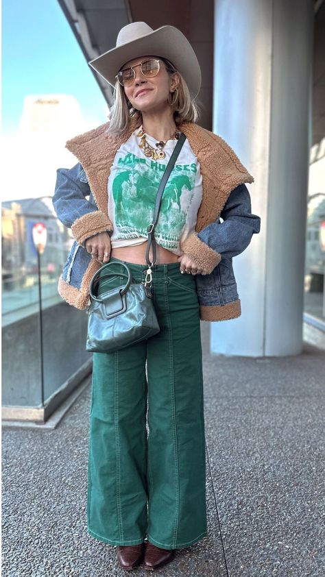 Upgrade your fashion game with a cowboy winter outfit! Create this look by pairing fun green wide-leg jeans with a casual graphic tee, a cozy denim jacket, and of course, matching Western boots and a modern cowboy hat. Don’t forget to add some extra accessories to complete the ensemble. Rock this cool look at a country concert, music festival, or any other event to totally stand out! Hunter Premo. Cowboy Winter Outfits for Women Cowboy Hat Outfit Woman Casual, Teal Cowgirl Boots Outfit, Sporty Western Outfits, Bluegrass Concert Outfit Winter, Cowboy Winter Outfits, Jean Concert Outfit, Cold Country Concert Outfit, Cowboy Hat Outfit Woman, Fall Country Outfits