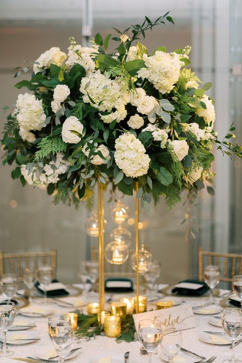 Green, Gold and White Glamorous Holiday Season wedding at Venue Six10 in Chicago, Illinois by wedding planner A Fresh Event (photo by Jenna Marie Photo) // Dramatic centerpiece with hanging candles Hanging Candles Centerpiece, White And Gold Wedding With Greenery, Emerald Green And Gold Centerpieces Wedding, White And Green Centrepiece Wedding, White And Gold Centerpiece, Gold White Flower Arrangement, White Green Gold Flower Arrangements, Hanging Tea Lights Wedding Centerpieces, Gold Vase White Flower Centerpieces