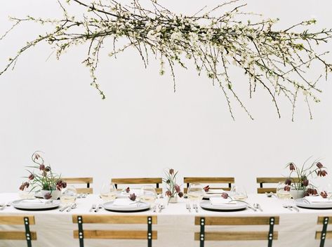 Simple and elegant spring centerpieces and place setting featuring a single stunning flower: plum-toned fritillaries, plus a hanging floral installation of blooming branches, make for a gorgeous and minimal tablescape with a lot of impact.    Flowers: Botanique  Photo: Anna Peters  Planning and Design: Callista Minimal Tablescape, Elegant Spring Wedding Ideas, Hanging Floral Installation, Minimal Wedding Decor, Spring Centerpieces, Branches Wedding, Blooming Branches, Centerpiece Inspiration, Wedding Branches