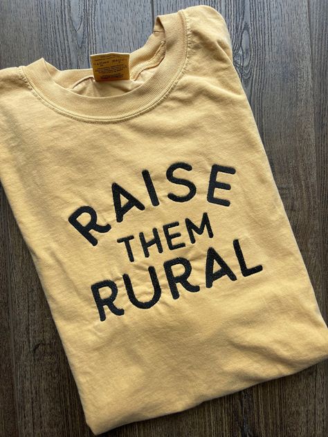 The most comfortable tee! Customize your t shirt with  the thread color of your choice!  EMBROIDERED DESIGN features a large bold font that reads "Raise Them Rural" OTHER SIZES AND COLORS AVAILABLE UPON REQUEST This shirt is Comfort Colors! .: 100% ring-spun cotton .: Medium fabric (6.1 oz/yd² (206.8 g/m .: Relaxed fit .: Sewn-in twill label **Each item is made to order, therefore we can not accept returns and exchanges. HOWEVER, if there is an issue with your order PLEASE contact us before leav Fun Mom Shirts, Inspirational Shirt Ideas, Farm Clothes Aesthetic, Mom Tshirt Ideas, Farming Shirts, Great Grandma Shirt, Farming Family, Hippie Mom, Country Boutique