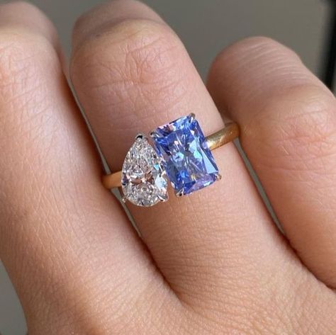 The Blue Moissanite adds a unique and colorful touch to the traditional toi et moi designs. A radiant and pear cut moissanite ring combines two different shapes of moissanite stones in one ring. A unique cathedral set two stone ring is another type of two stones are set on either side of the ring's band. This style is a great choice for those who want a non traditional and eye catching engagement ring. All three designs offer unique and beautiful ways to symbolize your commitment to your partner Real Diamond Engagement Rings Unique, Two Stone Engagement Ring Sapphire, Two Gemstone Ring, Two Stone Engagement Rings, Double Engagement Ring, Double Diamond Engagement Ring, Multi Stone Engagement Ring, Double Diamond Ring, Two Stone Engagement Ring