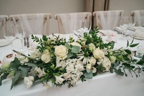 Classic green and cream flowers in Nathan and Chelsea's long and low table arrangement in the Doddington Hall coach house. The arrangement included roses, eucalyptus, alstromeria and lisianthus. 📷 Martin Cheung Photography White And Green Long And Low Flower Arrangement, Low Long Flower Arrangements, Long And Low Floral Centerpiece, Long And Low Flower Arrangement, Green And Cream Wedding, Table Centre Pieces Wedding, White Table Decorations, Green And White Wedding Flowers, White Wedding Flowers Centerpieces