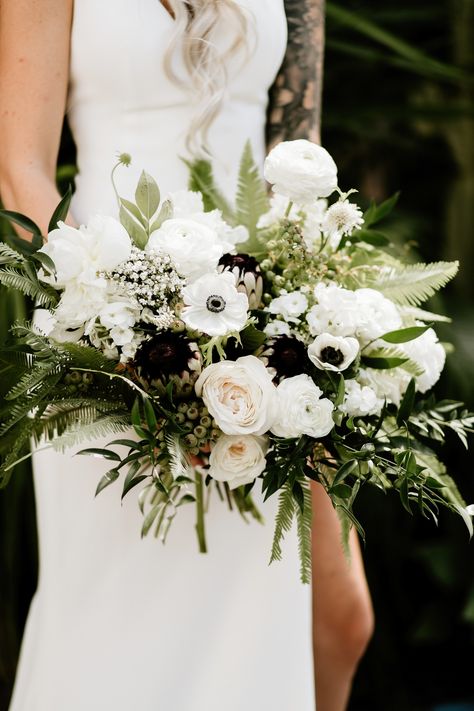 Black-and-white color palettes have a place in garden weddings, too. Just look to this The Little Branch bouquet for proof. White garden roses and ranunculus were accented by darker protea and anemone for a unique take on the otherwise romantic arrangement. Wedding Bouquets Black, Anemone Wedding, Best Wedding Colors, Flowers And Greenery, White Anemone, All White Wedding, Wedding Flowers Summer, White Wedding Bouquets, Black White Wedding