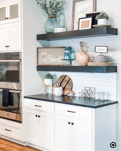 Cabinets With Floating Shelves Between, Kitchen With Black Shelves, Black Floating Shelves In Kitchen, Matte Black Floating Shelves Kitchen, Black And White Floating Shelves, Floating Shelves With Sconces Above, White Kitchen Cabinets With Wood Shelves, Floating Shelves Kitchen Black Countertop, Black Shelves In Kitchen