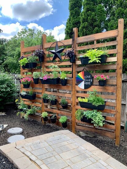 One of my favorite projects we've done is our pallet wall garden! It was a bit of sweat and muscle to get it put together and installed, but so worth it. The Perfect Privacy Fence Since the pool is above ground, the six foot fence doesn't cover as much as we'd like. And, it's a great backdrop for the pool.Want to build your own? Materials 6 pallets 4 4x4x12 posts 3" exterior screws Flood Exterior Stain (Cedar) 6 Bags of Paver Base Rectangular Hangers for Planters Rou… Pallet Wall Garden, Pallet Privacy Fences, Paver Base, Pallet Garden Walls, Rectangular Planter Box, Fence Planters, Herb Wall, Pallet Fence, Rectangular Planters