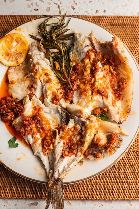 A plate of whole branzino, with the bones removed, topped with Calabrian chili sauce, lemon, and rosemary sprigs. Roasted Branzino, Bronzino Fish Recipe, Branzino Recipe, Calabrian Chili Paste, Chili Pasta, Calabrian Chili, Seafood Market, Delicious Seafood Recipes, Chili Paste