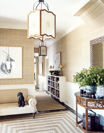 The Entryway  In the entrance hall, stripes of every stripe: on the settee, the hand-stenciled sisal rug, and the custom mirror frame. Lanterns from John Rosselli. The bookcase, built in to break up the long hallway, is lifted to create a sense of more floor space. Veranda Design, Look Wallpaper, Hall Rugs, Room Redo, Grasscloth Wallpaper, Updating House, A Living Room, Architectural Digest, Of Wallpaper