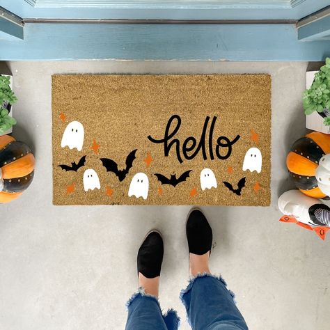 Welcome the spooky season with our charming handmade Halloween Doormat! This delightful doormat features a playful pattern of friendly ghosts, fluttering bats, and vibrant orange stars, all set against a backdrop that perfectly complements the bold "hello" text.  ✦Production time is 5-7 business days before shipping. Shipping is UPS Ground or USPS service. No PO Boxes, please. ✦All our coir welcome mats are natural brown in color. Minor variations are normal. ✦Each original design is available i Sip And Paint Halloween Door Mat, Spooky Rugs Diy, Door Mat Ideas Halloween, Door Mat Painting Diy Halloween, Halloween Door Mat Party, Painting Door Mats Diy Halloween, Pumpkin Door Mat, Halloween Outdoor Mat, Fall Mats Diy