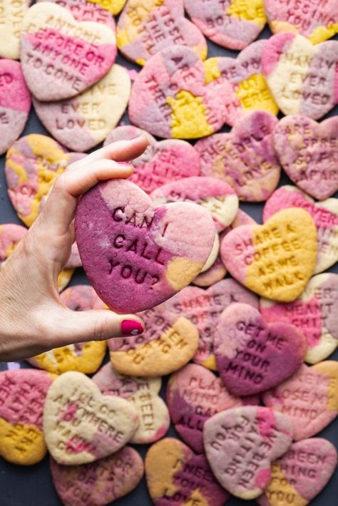 a hand with pink nail polish holding a marble-colored heart-shaped cookie that's purple, pink, and yellow with a message stamped on it that says: can I call you? Heart Sugar Cookies Recipe, Colored Sugar Cookies, Marble Sugar Cookies, Marble Cookies, Vegan Party Snacks, Crust Designs, Heart Sugar Cookies, Purple Cookies, Colored Cookies