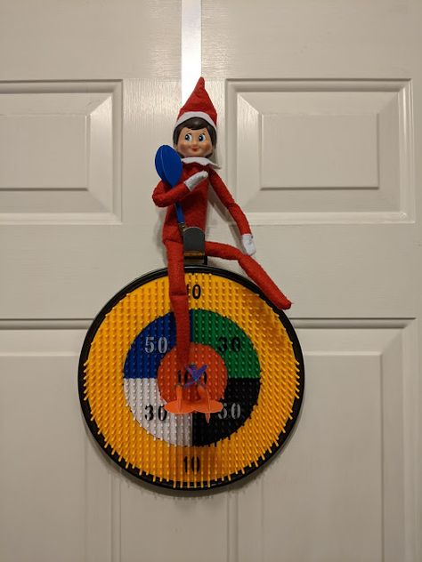 Elf on the Shelf playing darts Santa Cam, Elf Fun, Santa Decorations, Hiding Places, Elf On The Shelf Ideas, An Elf, Christmas Pins, Toilet Paper Roll, Dry Erase Board