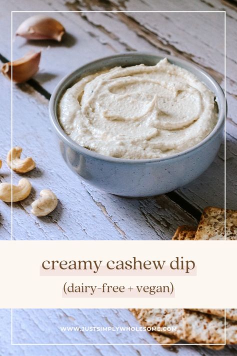 The pin shows an image of the creamy cashew dip in a light grey speckled bowl, sitting on a blue-grey wood background with garlic cloves, cashews and crackers scattered around. The text reads 'creamy cashew dip (dairy-free + vegan)' alongside the website 'www.justsimplywholesome.com'. Cashew Dip, Weekend Meal Prep, Hummus Dip, Cashew Cheese, Pantry Staples, Vegan Recipe, Nutritional Yeast, Family Friendly Meals, Bagels