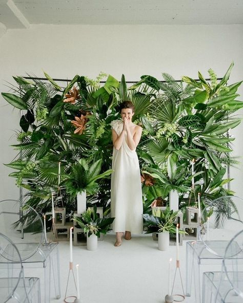 For something tropical with a modern, edgier twist, we love this ceremony backdrop constructed from loads of verdant tropical foliage. Concrete cinderblocks at the base display taper candles while the translucent ghost chairs round out this modern ceremony look. Wedding Walls, Wedding Fest, Laos Wedding, Ruangan Studio, Philippine Wedding, Aisle Decorations, Photo Booth Backdrop Wedding, Rustic Wedding Decorations, Booth Backdrops