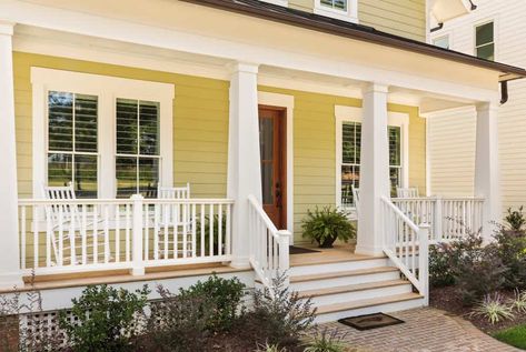 Close up shot of new yellow and white contemporary victorian style home in suburb. Porch spans front of home. Porch Column Wraps, Exterior Window Trim Ideas, Yellow House Exterior, White Porch, House Front Porch, Deck Colors, Porch Columns, Window Trim Exterior, Craftsman Exterior