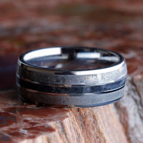 This mens meteorite wedding band has a dark inlay of crushed onyx between the gibeon meteorite. A titanium and meteorite ring is perfect for celebrating your vows.Astronomy jewelry attests to the magnificence that exists in our universe. This meteorite ring shows a fantastic Widmansttten pattern. It has been etched with an acid to reveal the characteristic patterns, or Widmansttten figures, of iron meteorites. No two etched meteorites will have the exact same pattern, making your wedding band a Mens Wedding Rings Vintage, Meteorite Engagement Ring, Meteorite Rings, Astronomy Jewelry, Meteorite Wedding Band, Band Ideas, Titanium Rings For Men, Meteorite Jewelry, Gemstone Wedding Rings