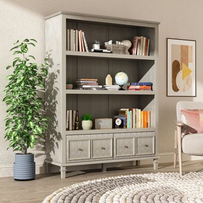 This stylish contemporary farmhouse bookcase is the ideal storage solution for your home office, living room, playroom, or other living space. It has a rustic and charming style, with a natural wood grain look complemented by vintage brass finish drawer pulls that fit seamlessly into almost any decor. The spacious shelves provide a versatile storage and display solution for your TV components, game consoles, audio equipment, DVDs, blu-rays, books, and more. The lower drawer is perfect for puttin Farmhouse Bookcases, Basement Room, Wood Shelving Units, Bookcase Wood, Open Display Shelf, Corner Bookshelves, Tall Bookcases, Furniture Bookshelves, Classic Gray