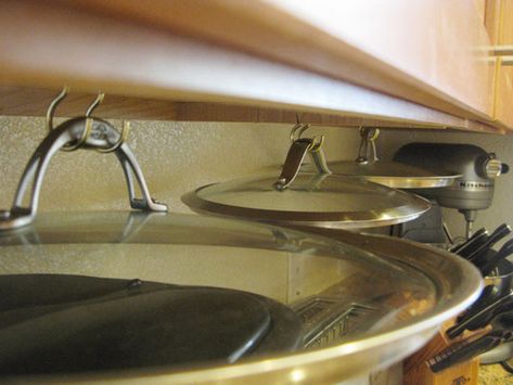 Store pot lids out of the way by hanging them under your kitchen cabinets Pot Lid Storage, Pan Storage, Small Kitchen Cabinets, Hanging Pans, Lid Organizer, Home Tips, Lid Storage, Kitchen Cabinet Organization, Pot Lids