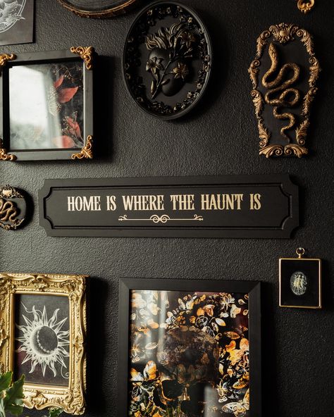 Give in to your heart's desire for spooky season with House of Persephone's "Home is Where the Haunt is" wall plaque. Perfect for those who embrace ghostly goodness all year-round, this sign is ideal for hanging in your living room, bedroom, entryway, or any spot that could use a bit of eerie elegance. The matte, black background paired with subtly reflective gold text creates a beautiful contrast that catches the eye without overpowering your decor. Whether you're looking to enhance your own da Spooky Maximalist Decor, Black Wall Gold Frames, Goth Fall Decor, Weird Core Decor, Earthy Gothic Decor, Witchy Home Decor Ideas, Spooky Decor Home, Dark Academia Hallway, Spooky Academia