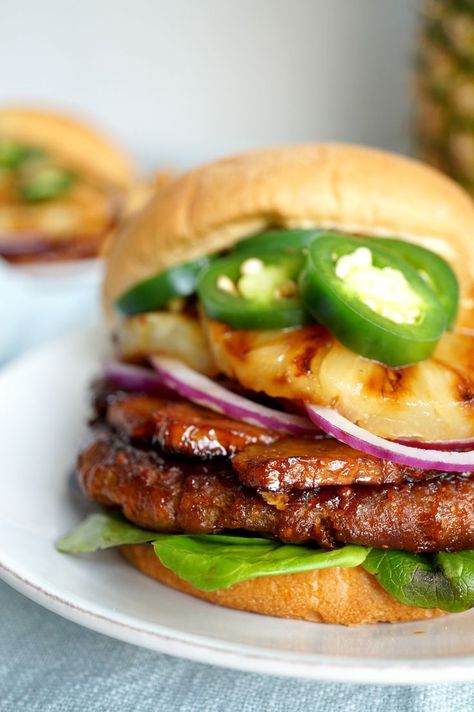 Who says vegan food is boring? This Vegan Aloha Burger is stacked high with homemade tempeh bacon, grilled pineapple, fresh jalapeños, and a vegan patty. It’s layers on layers of deliciousness! Aloha Burger, Vegan Patty, Tempeh Burger, Vegetarian Bacon, Beyond Meat Burger, Vegan Patties, Lazy Vegan, Vegan Barbecue, Tempeh Bacon