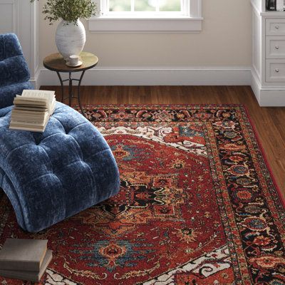 This Oriental rug features vibrant hues, a central medallion, and intricate floral motifs that draw on traditional Persian designs. It comes in rich red, black, blue, tan, and orange tones for an inviting look that also brings plenty of cushioning underfoot. Power-loomed in Turkey from polyester and polypropylene, this indoor area rug's 0.47" pile height makes it ideal for living rooms and dining rooms while remaining easy to clean. To keep it from shifting and sliding about, we recommend pairin Moody Persian Rug, Mid Century Living Room Rugs, Vintage Red Rug Living Room, Red And Black Rugs, Dark Persian Rug Living Room, Red Modern Living Room, Red Persian Rug Dining Room, Persian Rug Orange, Red Bedroom Rug