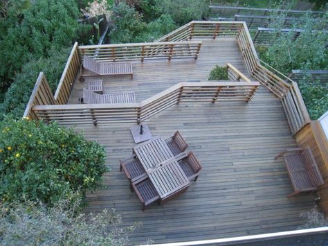 The sheer height of this deck allows occupants to see beyond the heavily landscaped gardens. The top tier features a dining area, while one of the lower tiers has lounge chairs for sunbathing. Deck Ideas On A Slope, Multi Level Deck Ideas, Multi Level Decks, Fire Pit Decor, Multi Level Deck, Tiered Deck, Deck And Patio, Large Backyard Landscaping, Small Fire Pit