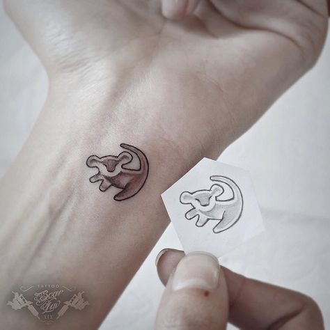 Makeup, Beauty, Hair & Skin | 12 Tiny Simba Tattoos For Those Who Just Can't Wait to Be King | POPSUGAR Beauty Matching Disney Tattoos, Lion King Tattoo, Petit Tattoo, Mouse Tattoos, Tattoo Trend, Shape Tattoo, King Tattoos, Cat Tattoos, Harry Potter Tattoos