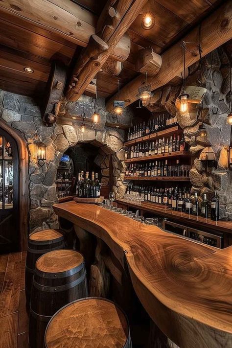 A rustic wine cellar bar featuring stone archways, a polished wooden countertop, and barrel-style stools. The walls are lined with shelves full of wine bottles, creating a cozy, inviting atmosphere for wine lovers. Rustic Bars For Home, Wood Bar Countertops, Wine Cellar Design Rustic, Wine Barrel Bar Ideas, Rustic Wine Cellar, Sedona House, Rustic Home Ideas, Whiskey Bars, Cabin Update