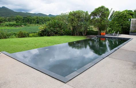 Exposed aggregate pool deck around black bottom pool Pool With Dark Coping, Exposed Aggregate Pool Deck, Exposed Aggregate Pool, Pool With Aggregate Concrete, Exposed Aggregate Pool Surround, Aggregate Concrete Pool Deck, Brushed Concrete Pool Deck, Black Bottom Pools, Pool Coping Tiles