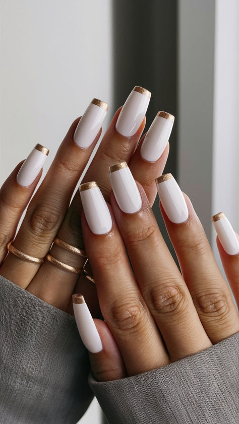 Elevate your nail game with this stunning white manicure featuring luxurious gold tips! This eye-catching design combines a crisp, clean base with a touch of glamour, making it perfect for both casual outings and special events. The gold accents add a modern twist, creating a look that’s effortlessly chic. Get inspired to shine bright with this elegant nail art! 🌟 White French With Gold, Cream And Gold Nails, White Nails With Gold Design, Gold Manicure, White Nails With Gold, Elegant Nail Art, Wow Nails, Basic Nails, White Nail Designs