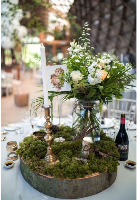 a woodland wedding centerpiece of a wood slice, moss, blooms and greenery in a jar, feathers and candles Boho Chic Forest Wedding, Woodland Fairy Wedding Table Decor, Nature Themed Table Decor, Moss Decorations Wedding, Moss Table Wedding, Woodland Wedding Table Decor, Enchanted Woodland Wedding, Moss And Blush Wedding, Enchanted Forest Wedding Table