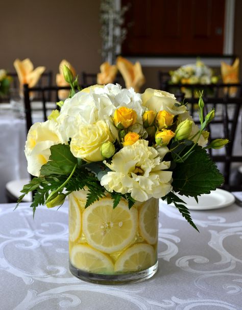 Lemon Centerpiece with Cream Flowers Lemon Bridal Shower Theme Centerpieces, Lemon And Flowers Centerpiece, Main Squeeze Bridal Shower Centerpieces, Lemon In Vase With Flowers, Lemon Tablescape Spring, Lemon And Lime Centerpieces, Lemon Flower Centerpiece, Centerpieces With Lemons And Flowers, Lemon Tree Centerpieces