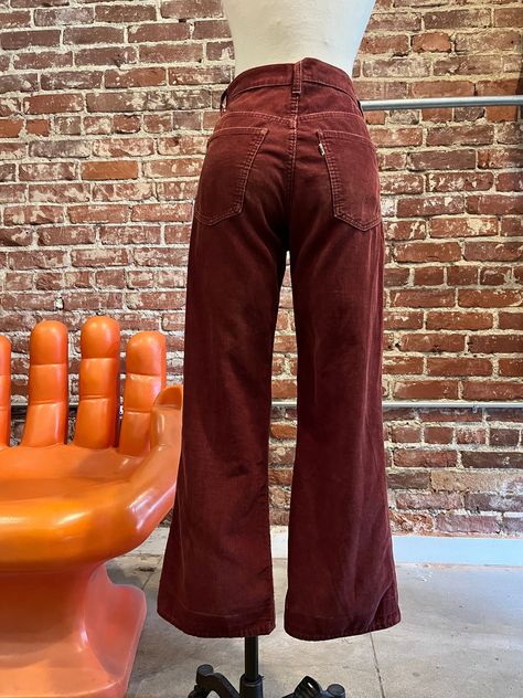 70s Levi's Cabernet Corduroy Flared Jeans Gorgeous seventies Levi's corduroy flared jeans. Talon 42 zipper fly with Levi's signature button closure at the waist. Front and back pockets. Belt loops for your favorite 70s belt. The color is so good! Levi's white tab on the back pocket. These are extremely old Levi's. The Levi's button and the zipper are oxidized. Demarcation and discoloration through out, especially where the hem has been taken down. A fray and a mend near the right hem. A fray on the right front pocket and slightly frayed at the waist. I've added as many photos as I can of this. I love these 70s Levi's and I think the imperfections make them look that much cooler. Please DO NOT purchase if the imperfections bother you.  Measurements: 28" waist 37" hip-hip measurement is key, 70s Style Jeans, 70s Street Fashion, 70s Jeans Outfit, Authentic 70s Fashion, 70s Winter Fashion, 60s Jeans, 70s Trousers, 70s Cottagecore, 70s Inspired Outfits