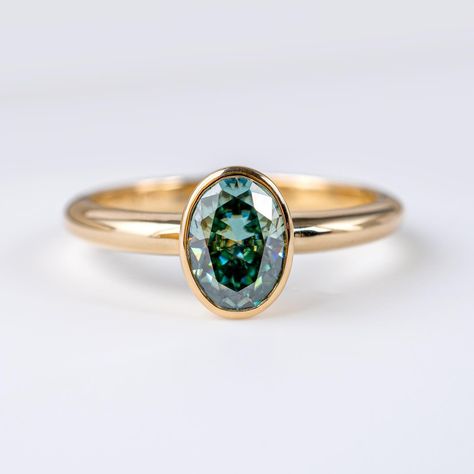 🌟 Introducing our newest addition: Oval Teal Green Moissanite Solitaire Bezel Ring! 💍 Crafted from solid 9ct yellow gold, this ring exudes elegance and sophistication. Each ring is hallmarked with full British assay marks and our own mark, guaranteeing its quality and authenticity. Available sizes: M and P 💎 Moissanites are renowned for their strength and durability, ensuring this ring will be cherished for a lifetime. DM me with any questions! Michael :) #MoissaniteRing #TealGreen #... Green Moissanite, Prong Engagement Rings, Bezel Set Engagement Ring, Green Oval, Bezel Ring, Wedding Goals, Dream Ring, Rings Simple, Moissanite Rings