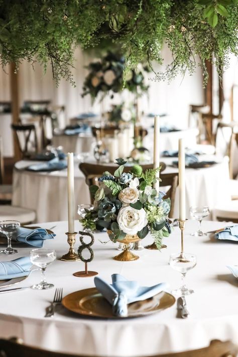 Enchanting candlelit wedding centerpieces Brass Candlesticks Wedding Centerpieces, Wedding With Dusty Blue, Round Table Centerpieces Wedding, Wedding Tablescapes Round, Taper Candle Centerpiece, Candlestick Centerpiece Wedding, Round Table Centerpieces, Taper Candles Wedding, Round Wedding Tables